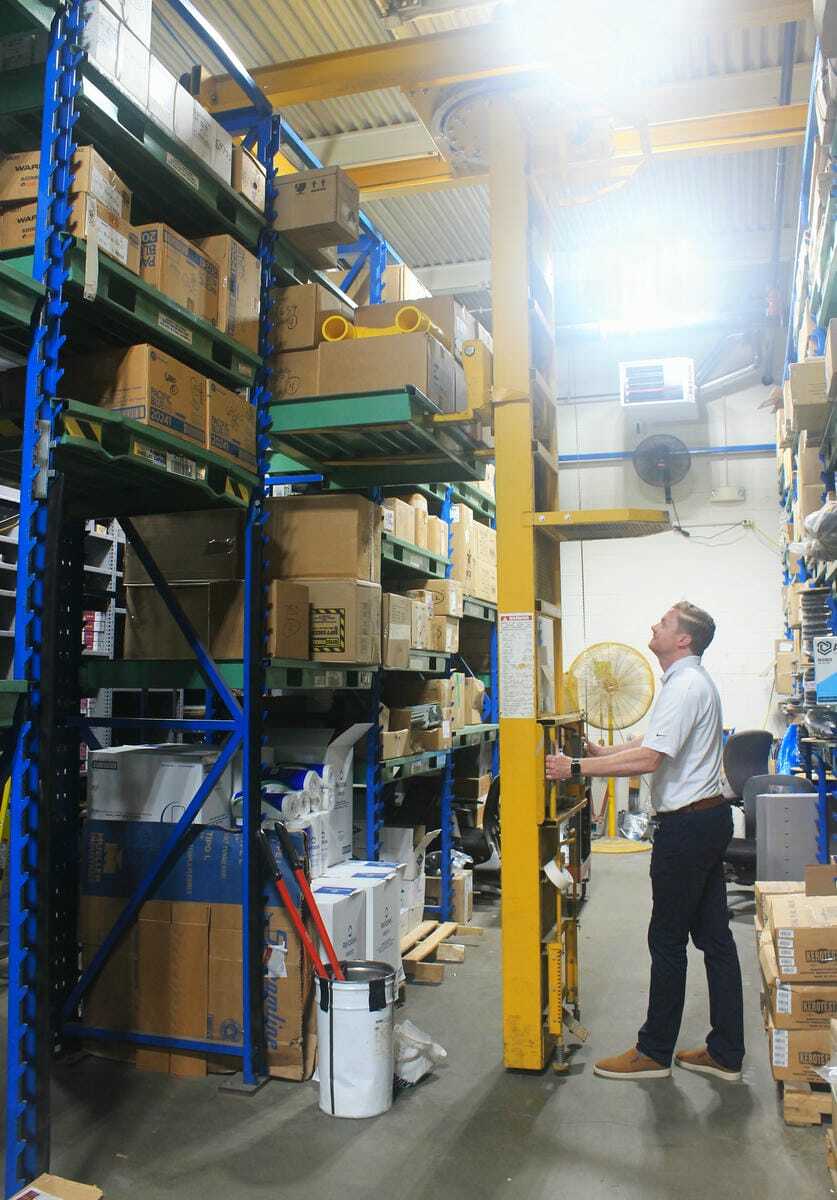 Worker using crane system in narrow aisle setup